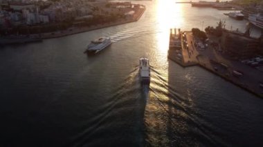 Drone view of the entrance to the Port of Piraeus with two boats at sunset.