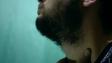 Doğulu görünümlü bir adam tıraş olmadan önce sakalını keser. Güzel siyah ve kalın sakallı, anlamlı özellikleri var. Planı kapat.