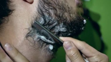 Sakal tımarlama ritüeli. Sakalını aşağıdan düz bir usturayla kesiyor..