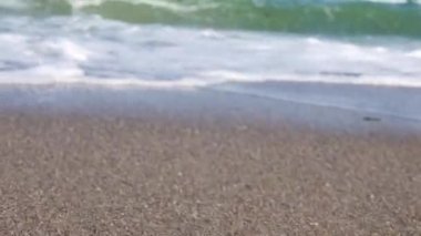 Küçük bir fırtına sırasında küçük çakıl taşlarıyla güzel bir plajı vurmak. Mavi deniz gümüşi kıyıya çarpar.