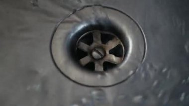 Yuvarlak delikli bir mutfak lavabosuna boşalt. Su paslanmaz çelik lavaboya boşalır..