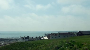 Mavi Kuzey Denizi 'nin arka planına karşı küçük İskoç evleri manzarası. Mayıs ayı başlarında küçük bir İskoç kasabası olan Arbroath 'da çekimler.
