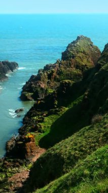 Kuzey Denizi kıyısında parlak bir yaz manzarası çekiyoruz. Sulu yeşil kayalar sakin bir denizde sınırdır..