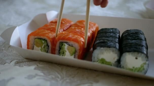 Model Bețișoare Care Încearcă Rola Sushi Dintr Cutie Fundal Alb — Videoclip de stoc