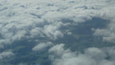 Beyaz bulutların ve mavi gökyüzünün hava fotoğrafları. Uçağın kanadı da kareye giriyor..