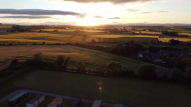 Önünde güzel yeşil tarlalar olan güzel bir günbatımı. Çiftlik işçileri kampının yakınında vurulmuş..