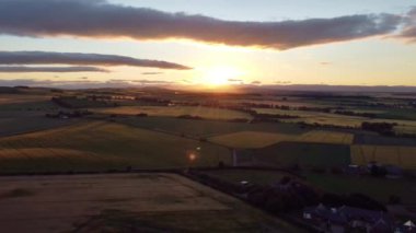 Yeşil tarlalı bir gün batımının insansız hava aracından ateş etmek. Bulutlar gökyüzüne yayıldı.