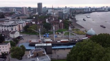 Londra 'da anıt gibi duran büyük bir geminin insansız hava aracı görüntüleri. İnsansız hava aracıyla pürüzsüz bir şekilde paketlenmiş. Sağda Thames Nehri var, ve arka planda metropolün sonsuz evleri var..