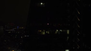 İnsansız hava aracı, bir gökdelenin zayıf aydınlatılmış pencerelerinin yanında uçuyor. Londra 'nın en ünlü gökdelenlerinden biri..