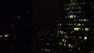 Geceleri Londra 'daki birkaç gökdelenin insansız hava aracı görüntüsü. Geceleri insanların çalıştığı sonsuz pencere ışıkları..