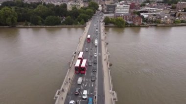 Aerial view of Putney Bridge and bus stop on it. Red double-decker buses lined up before stopping.