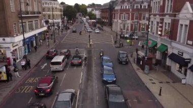 Londra 'da bir trafik lambasına parketmiş araçlarla kavşağın insansız hava aracı görüntüsü. Eylül ortasında gündüz çekimleri.