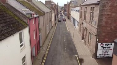 İskoçya, Arbroath 'ta iki katlı dar bir caddenin insansız hava aracı görüntüsü. Tipik bir İskoç kasabasında tek yönlü bir caddeye yakın çekim.