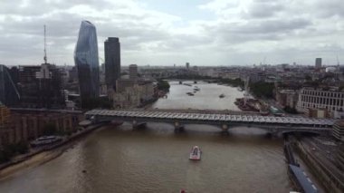 Londra 'nın iş bölgesindeki Thames Nehri' nin insansız hava aracı manzarası etrafında iki köprü ve yüksek binalar var..