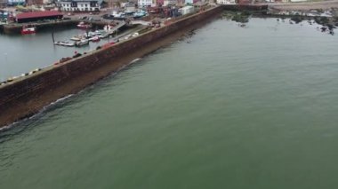 İskoçya 'nın Arbroath kasabası ile rıhtımın yakınındaki deniz manzarası. Eylül ayı başlarında bulutlu havada çekim.