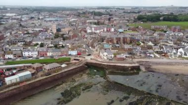 Dalgalar alçaldığında Arbroath rıhtımının insansız hava aracı görüntüsü. Evler set boyunca sıralanır..