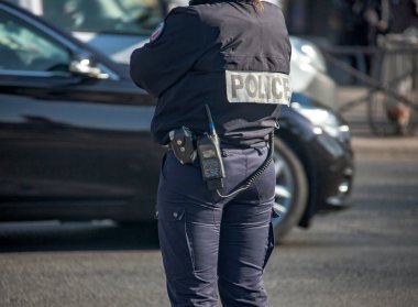 Paris 'te trafiği düzenleyen donanımlı bir kadın polis. Fransa sokaklarında bir polis memuru kamu düzenini kontrol ediyor..  