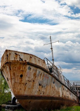 Baykal Gölü kıyısında pas ve yıkım izleri taşıyan eski bir tekne. Filo ve araba lastiklerinin kalıntılarıyla Baykal Gölü kıyılarının kirlenmesi ve kirlenmesi. 