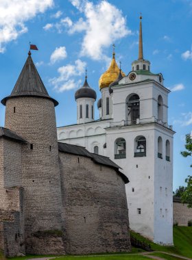 Yazın gökyüzünün arka planında Trinity Katedrali, Çan Kulesi ve Saat Kulesi kubbeleri olan Pskov Kremlin. Pskov Krom 'un tahkimatlı ve Ortodoks manzaralı tarihi bir manzara. Rusya