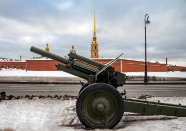 Sovyet 122 mm havan topu modeli 1938 M-30 Peter ve Paul Kalesi 'nin arka planında. Saha silahı 1939 'dan 1955' e kadar seri olarak üretildi, birçok orduya hizmet etti, 20. yüzyılın savaşlarında ve çatışmalarında kullanıldı.. 