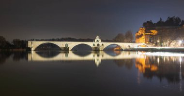 Gece Pont Saint Benezet ve Avignon 'daki Papa Sarayı ve Fransa' nın Provence kentindeki Rhone 'u yansıtıyor.