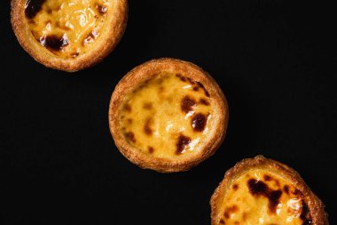 Pastel de nata tatlı kapağı siyah arka plan, karanlık ve karamsar