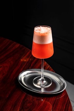 Yenilebilir çiçeklerle süslenmiş güzel bir şarap kadehinde köpüklü ferahlatıcı bir kokteyl.