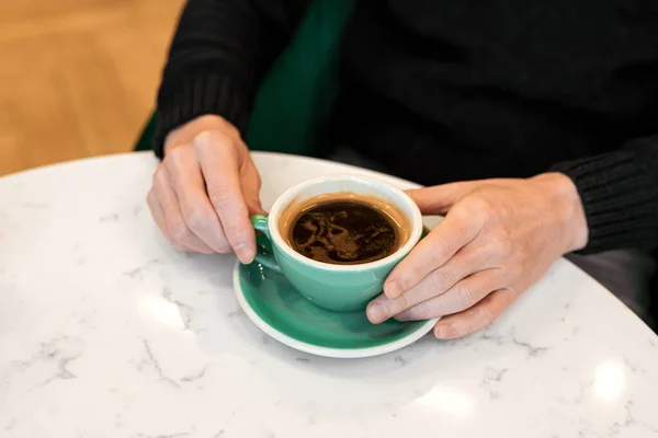 Homem Segurando Uma Xícara Café Preto Quente Suas Mãos Sentado — Fotografia de Stock