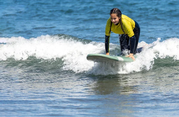 Woman surfing while kneeling on a surfboard