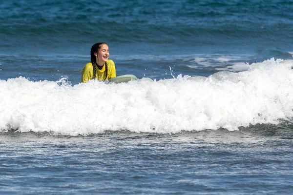 Smiley and happy woman surfing in the sea in a sunny say