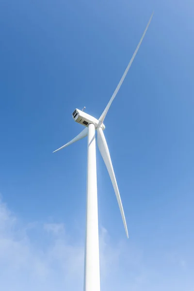 Mavi gökyüzü olan bir yel değirmeninin elektrik türbininin üst kısmının görüntüsü