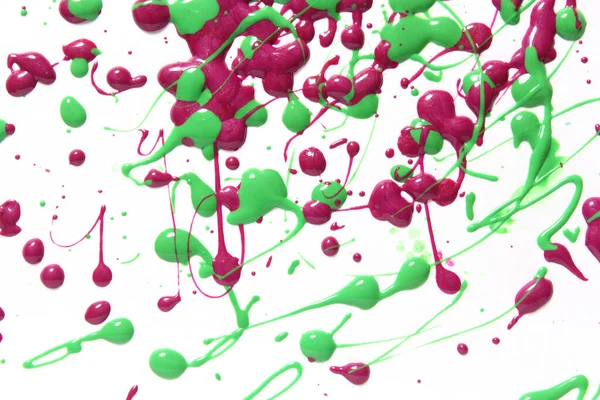 Rosa und grün verschütteter Nagellack auf weißem Hintergrund — Stockfoto