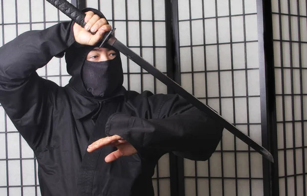 Asian Man Wearing Ninja Costume and holding Ninja Weapons — Stockfoto