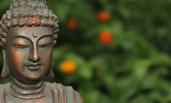 Posąg Buddy Ogrodzie Rozmytymi Kwiatami Tła — Zdjęcie stockowe