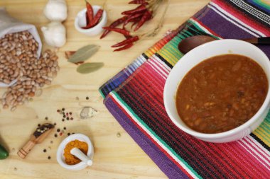 Arka planda biberli, baharatlı ve kuru fasulyeli Pinto fasulyeli bir kase biber.