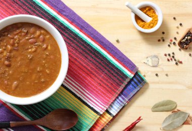 Arka planda biberli, baharatlı ve kuru fasulyeli Pinto fasulyeli bir kase biber.