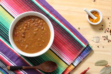 Arka planda biberli, baharatlı ve kuru fasulyeli Pinto fasulyeli bir kase biber.