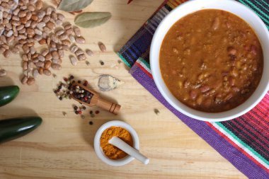 Arka planda biberli, baharatlı ve kuru fasulyeli Pinto fasulyeli bir kase biber.