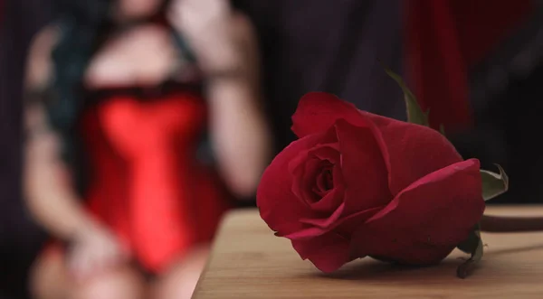 Rosa vermelha com mulher no espartilho vermelho no fundo — Fotografia de Stock
