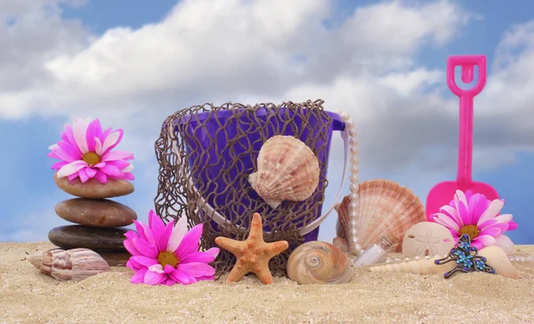 Sand Pail With Net and Sea Shells on Sand With Sky
