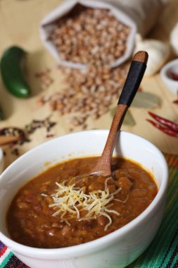 Arka planda biberli, baharatlı ve kuru fasulyeli Pinto fasulyeli bir kase biber.