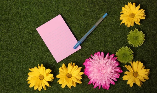 Blank Note Papier Sztuczne Zielone Trawy Tle Kolorowymi Kwiatami — Zdjęcie stockowe