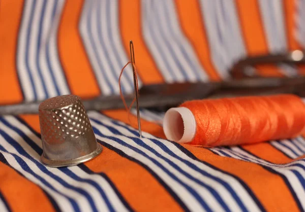 Turuncu ve Beyaz Kumaşlı Portakal İplik ve Yüksük Makasları Arkaplanda