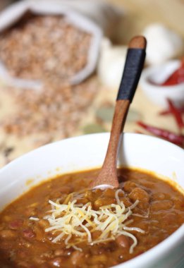 Arka planda biberli, baharatlı ve kuru fasulyeli Pinto fasulyeli bir kase biber.