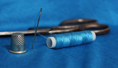 Mavi İplik, Yüksük ve Şırınga Mavi Kumaşta Arka planda Eski Makas