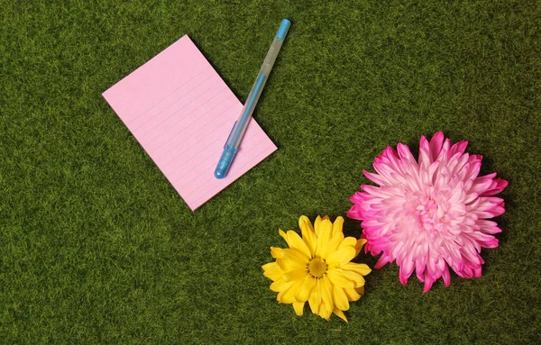 Blanco Notitie Papier Kunstgras Achtergrond Met Kleurrijke Bloemen — Stockfoto