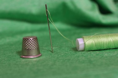 Yeşil İplik, Yüksük ve İğne Makarnası Yeşil Kumaşa Yaklaş