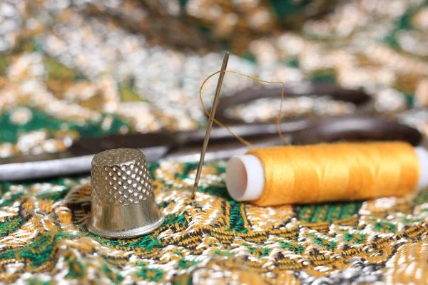 Thread dourado e dedal em tecido vintage do Oriente Médio — Fotografia de Stock
