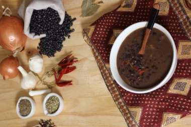 Baharatlı ve kuru fasulyeli, ahşap masadaki siyah fasulye.