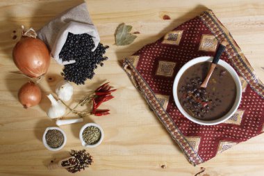 Baharatlı ve kuru fasulyeli, ahşap masadaki siyah fasulye.